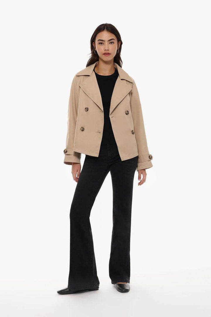 Full body front view of woman wearing beige oversize trench coat

