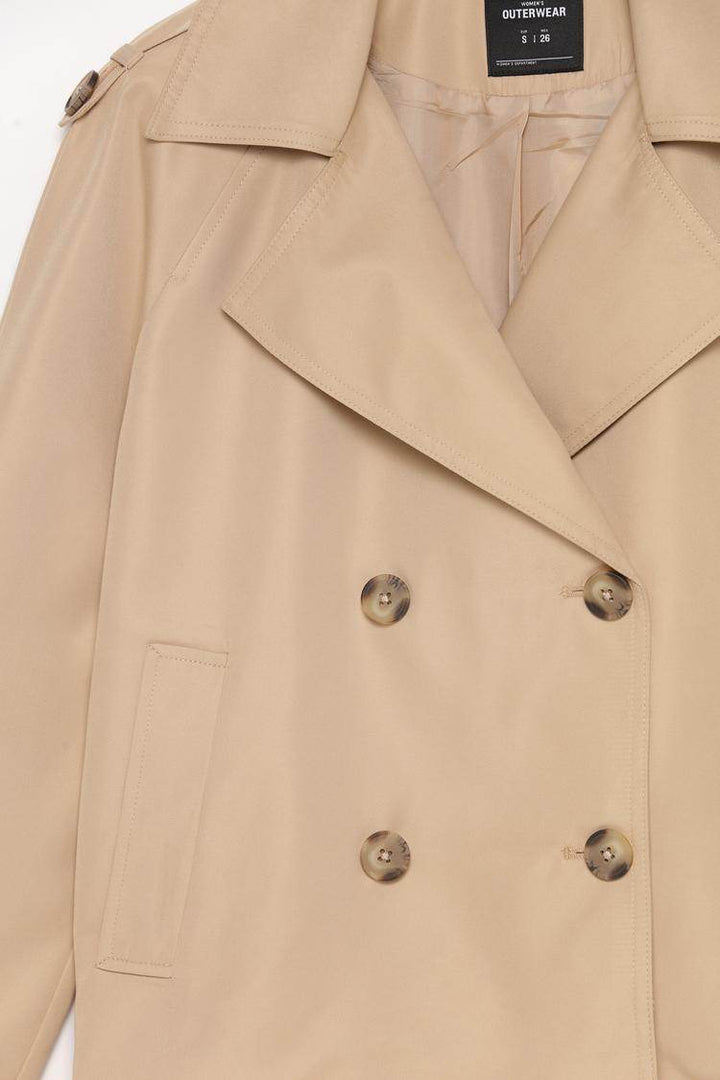 Close-up product image of beige trench coat fabric


