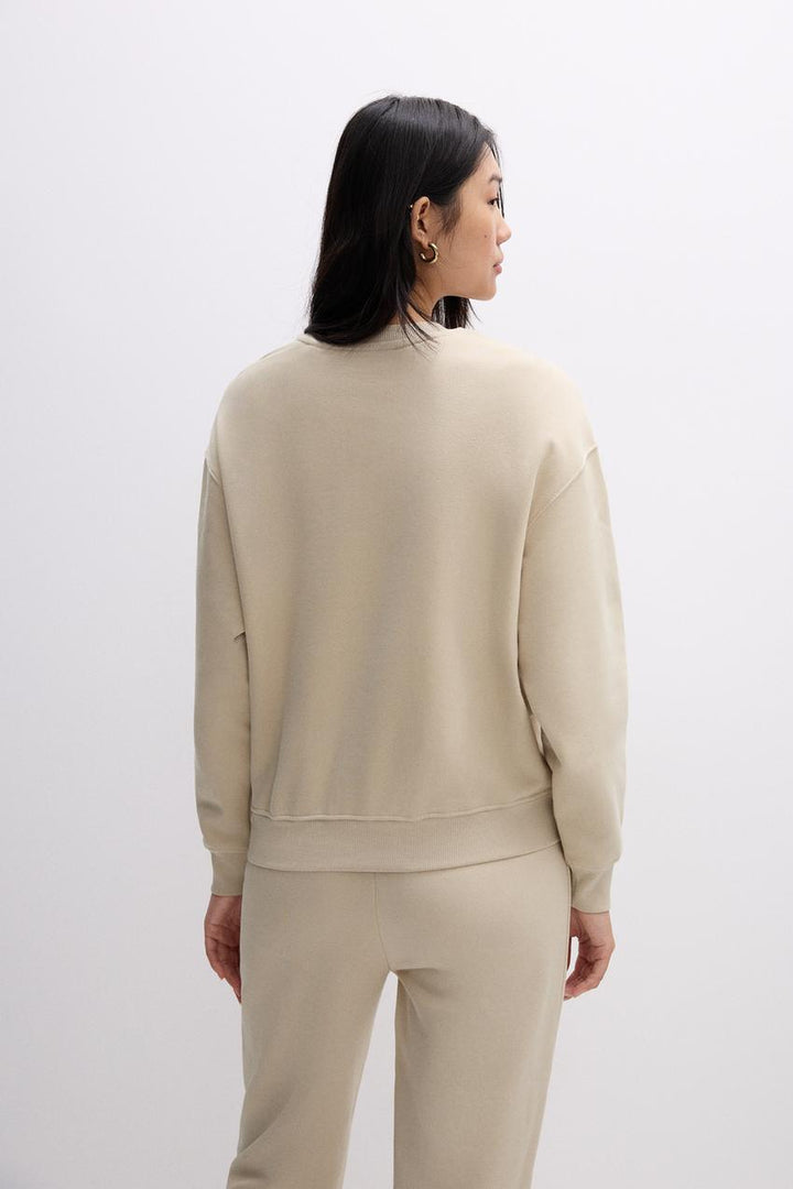 Back view of a beige women's sweatshirt
