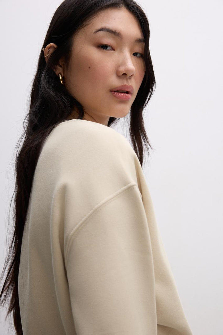 Side view of a beige women's sweatshirt

