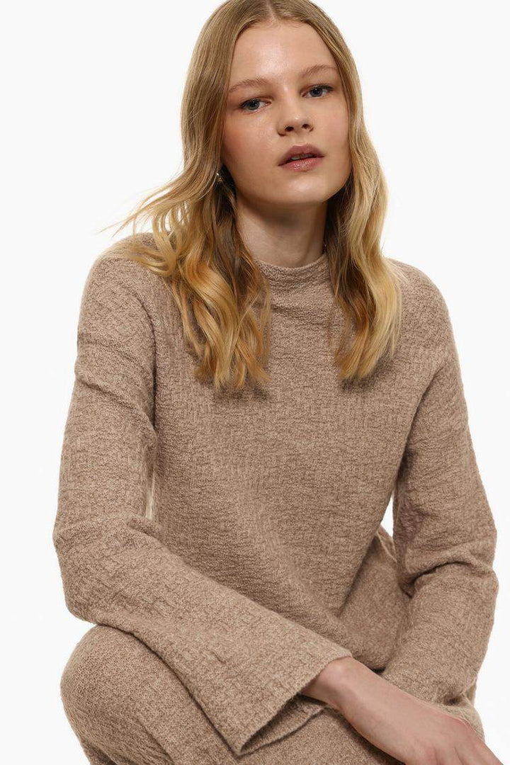 Model showcasing beige textured knit sweater front

