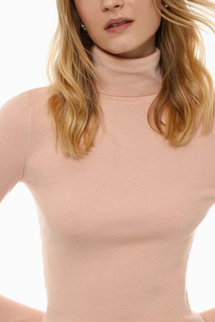 Close-up front view of beige turtleneck sweater

