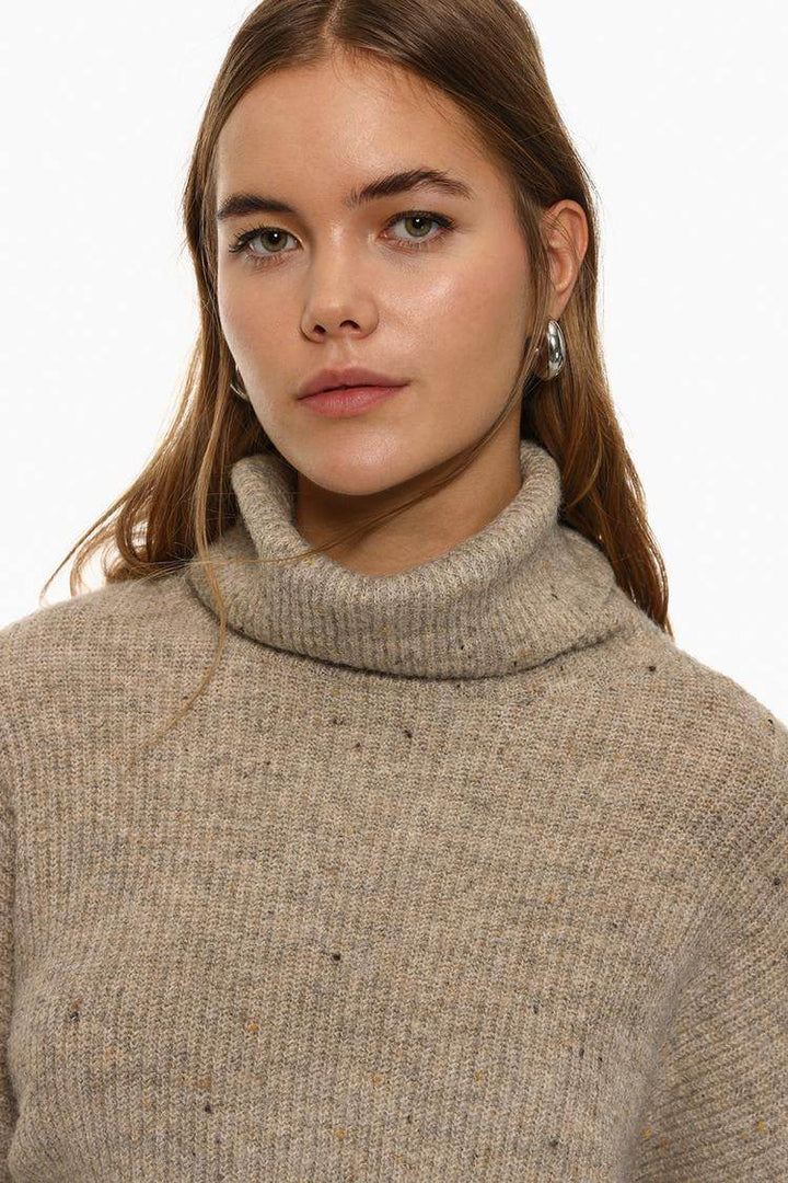 Close-up front view of beige turtleneck sweater

