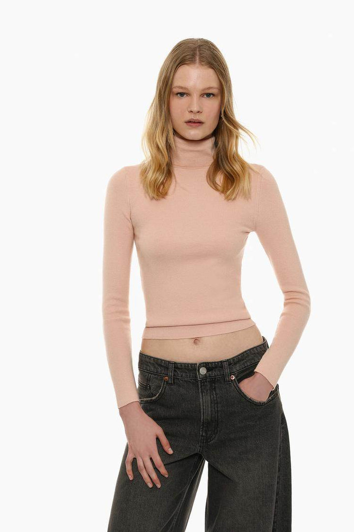 Front view of women's beige turtleneck sweater

