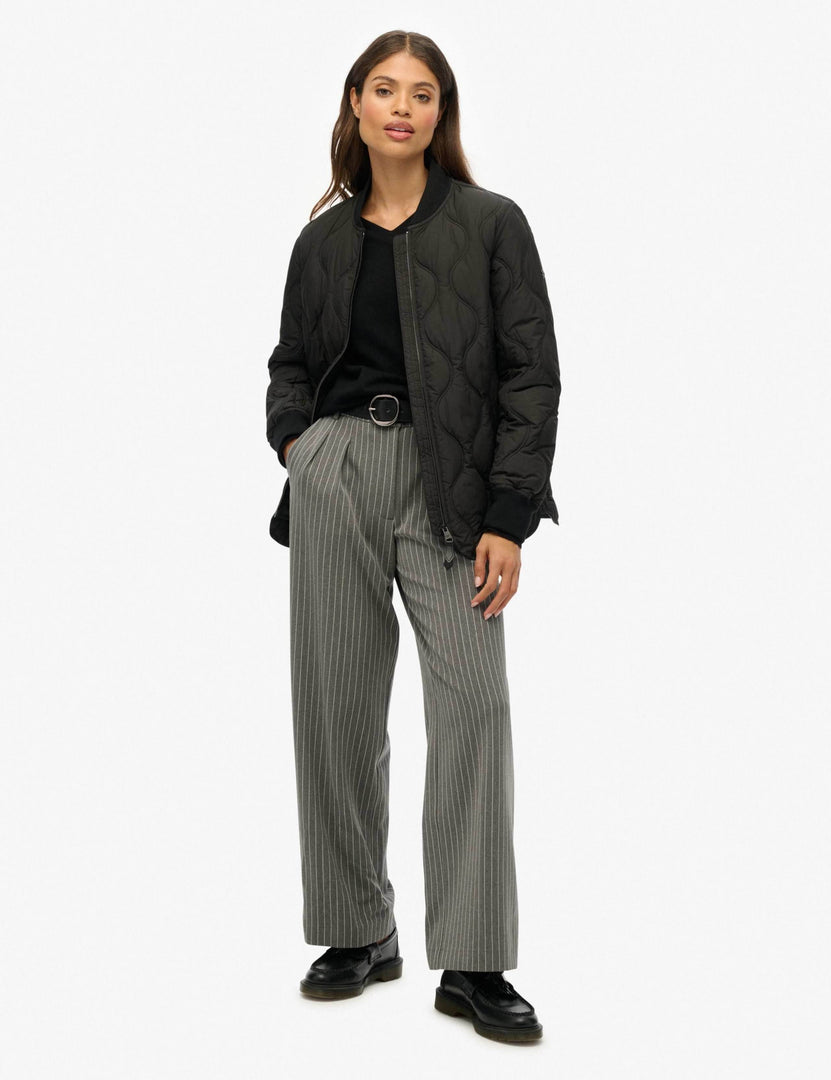 Full body front view of a woman wearing a black baseball collar jacket

