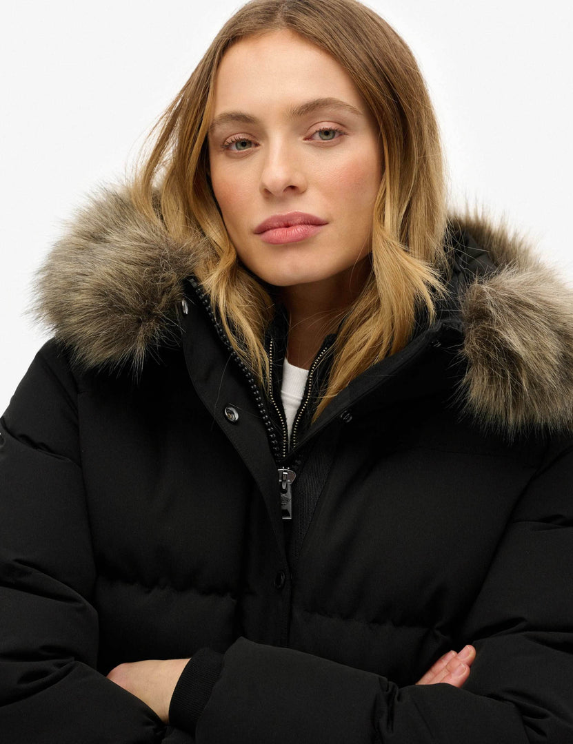 Close-up of the black hooded funnel neck puffer jacket's material

