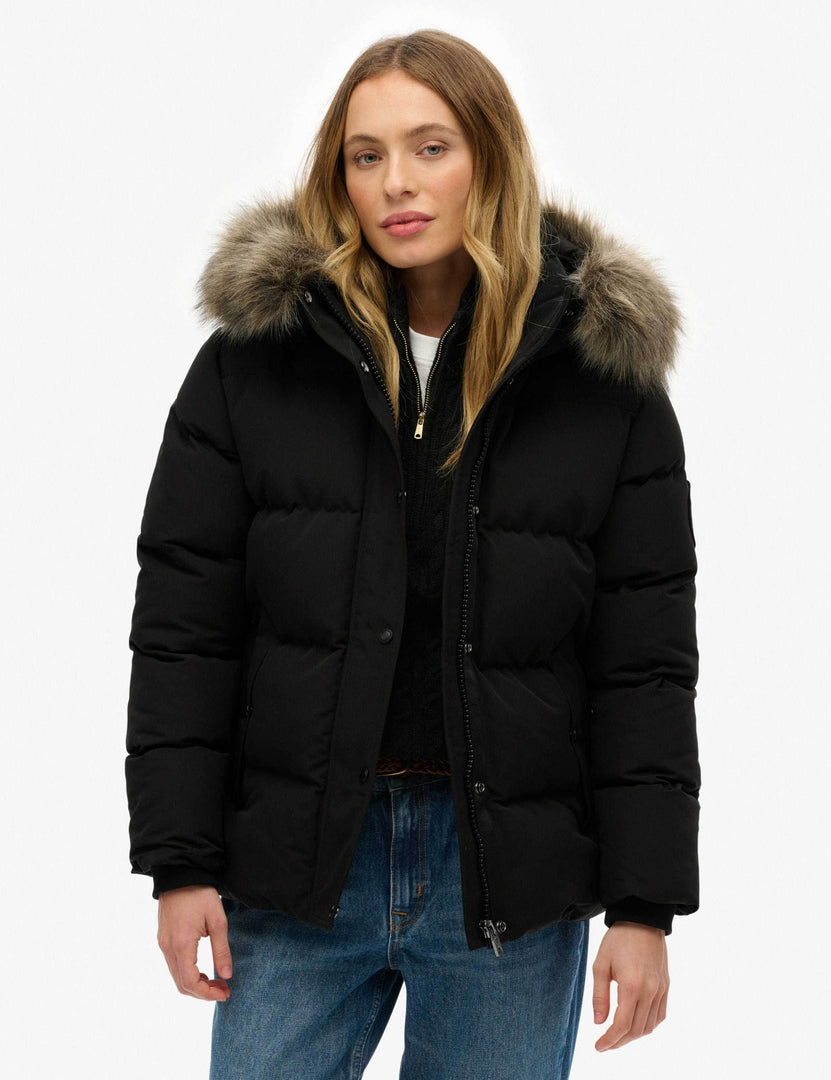 Front view of a women's black hooded funnel neck puffer jacket

