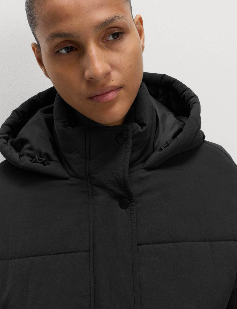 Close-up front view of the black hooded puffer jacket

