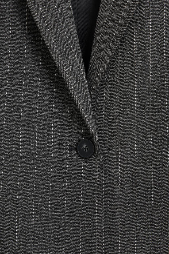 Zoomed view of a black women's pinstriped blazer
