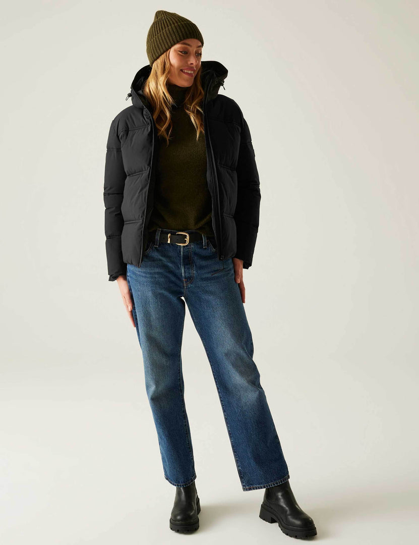 Full body front view of a woman wearing a black quilted puffer jacket

