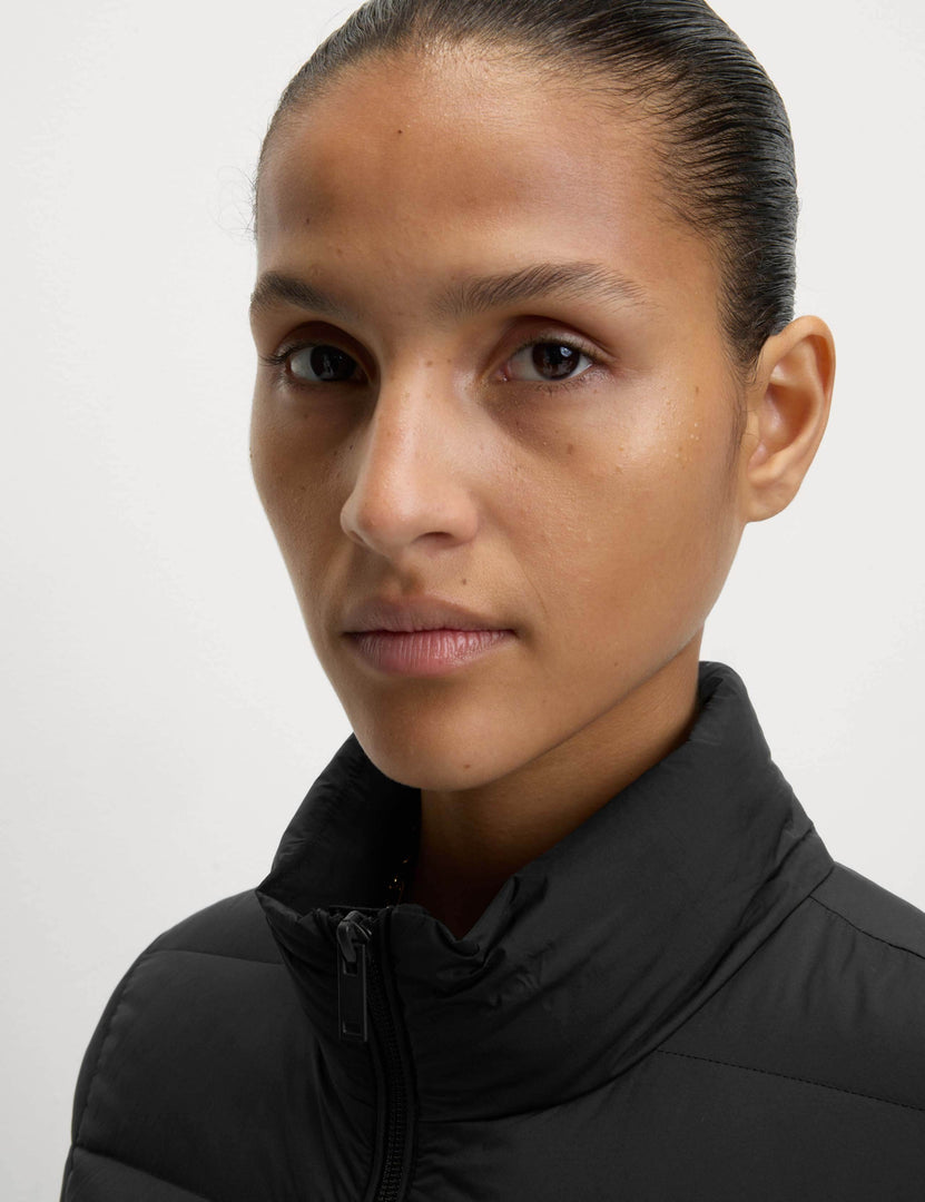 Close-up of a woman modeling the black puffer jacket


