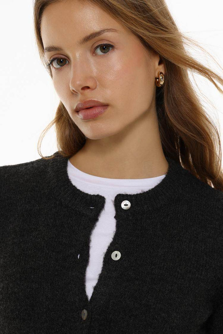 Close-up front view of black knit cardigan

