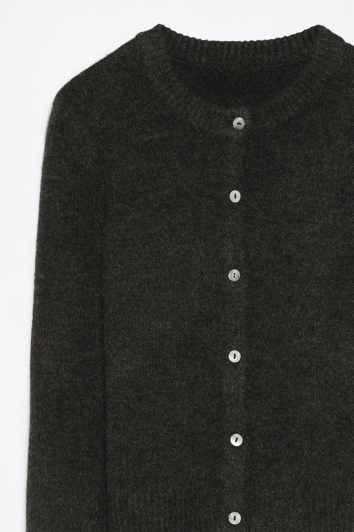 Close-up product image of black knit cardigan fabric

