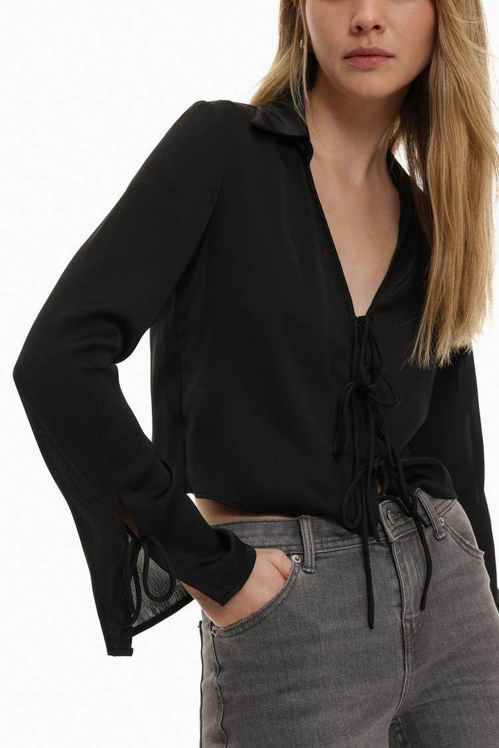 Model showcasing front of black satin shirt with ties

