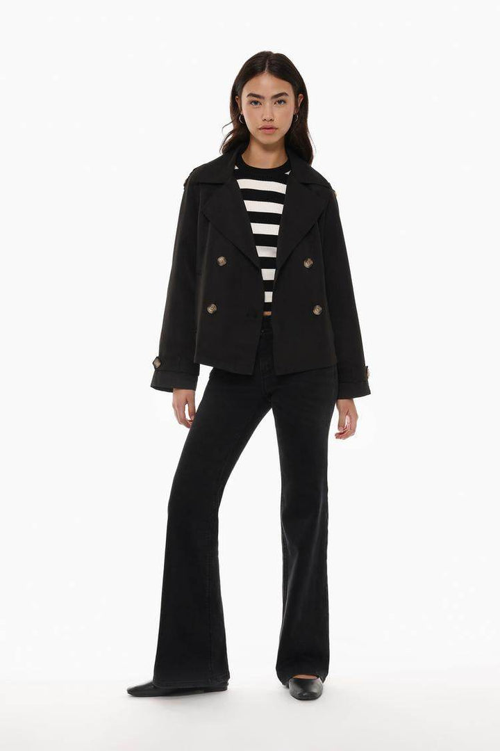 Full body front view of woman wearing black trench coat

