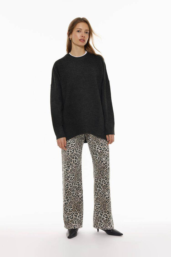 Full body front view of woman wearing black oversize jumper

