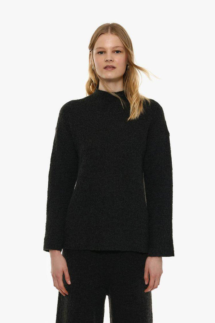 Front view of women's black textured knit sweater

