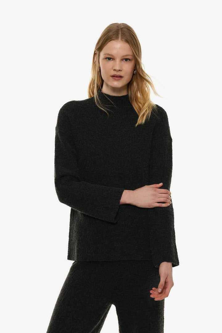 Model showcasing black textured knit sweater front

