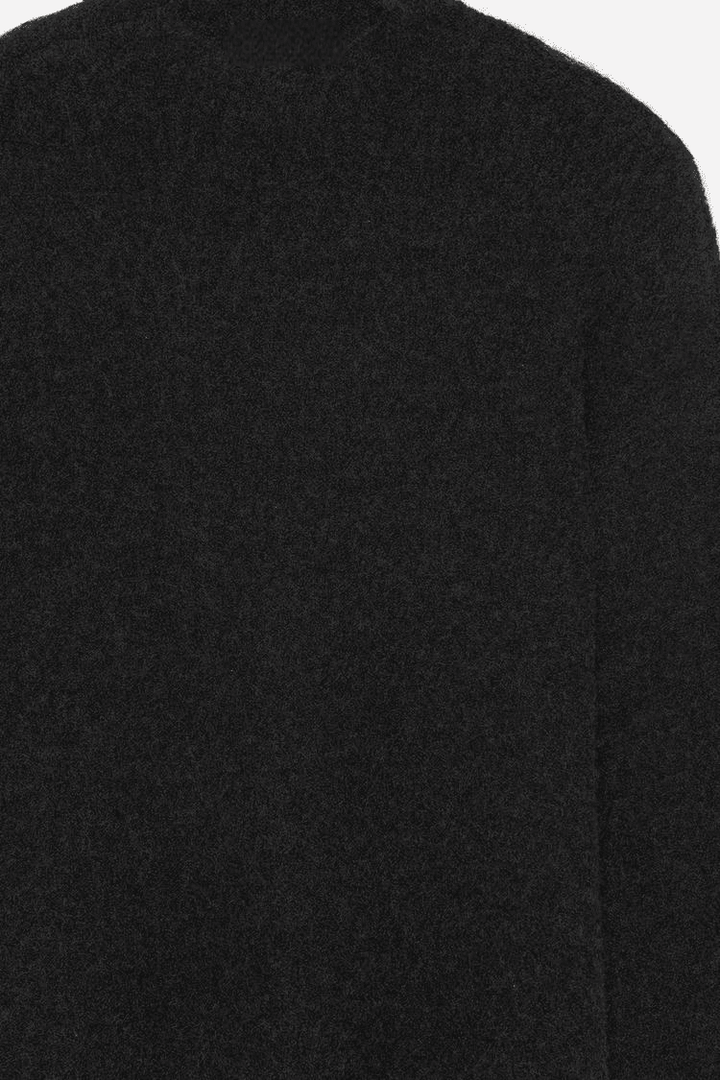 Close-up product image of black textured knit sweater


