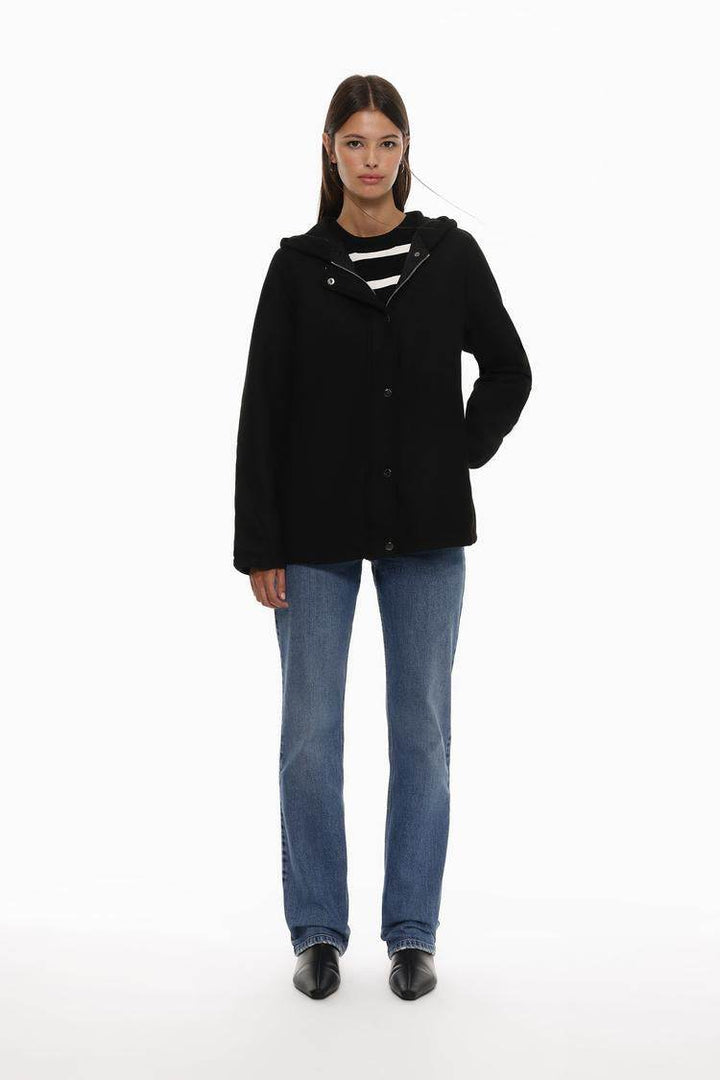 Full body front view of woman wearing black wool coat

