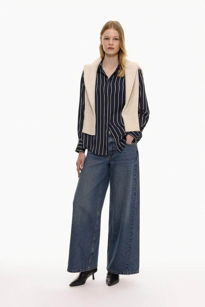 Full body front view of woman wearing blue satin shirt

