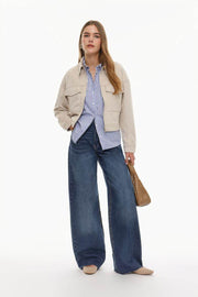 Full body front view of a woman wearing blue wide-leg jeans

