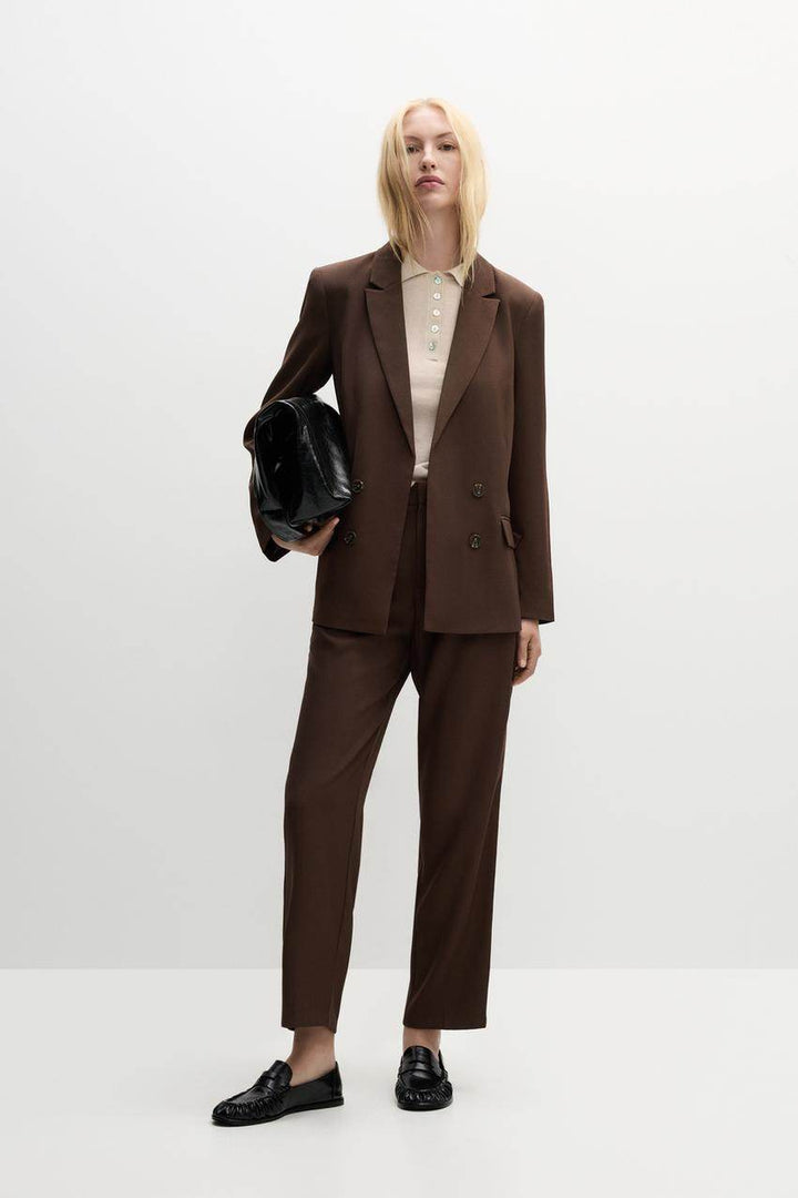 Full body front view of a woman wearing a brown blazer

