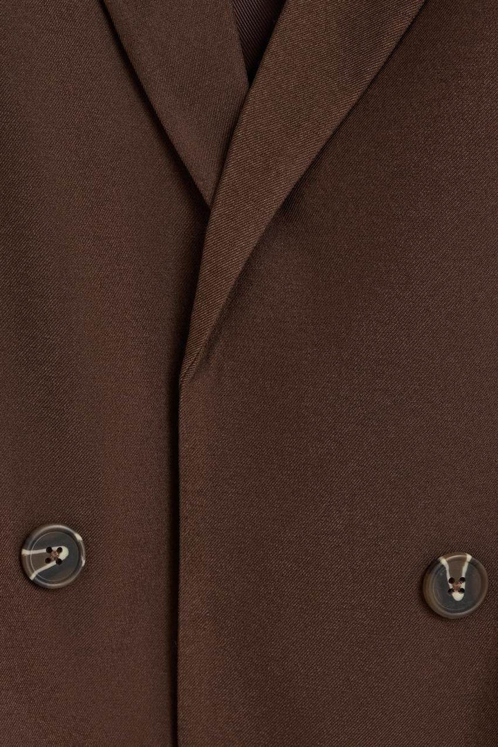 Close-up of the brown blazer's fabric and texture

