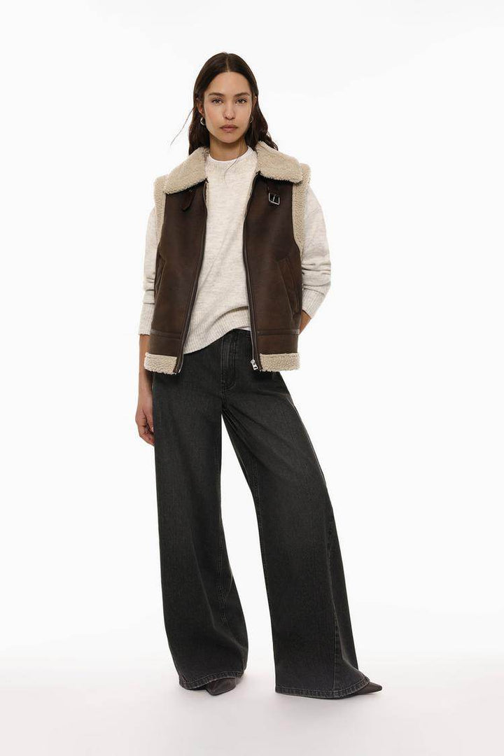 Full body front view of woman wearing brown double-faced gilet

