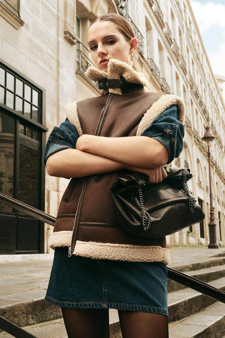 Street style photo of woman wearing brown double-faced gilet

