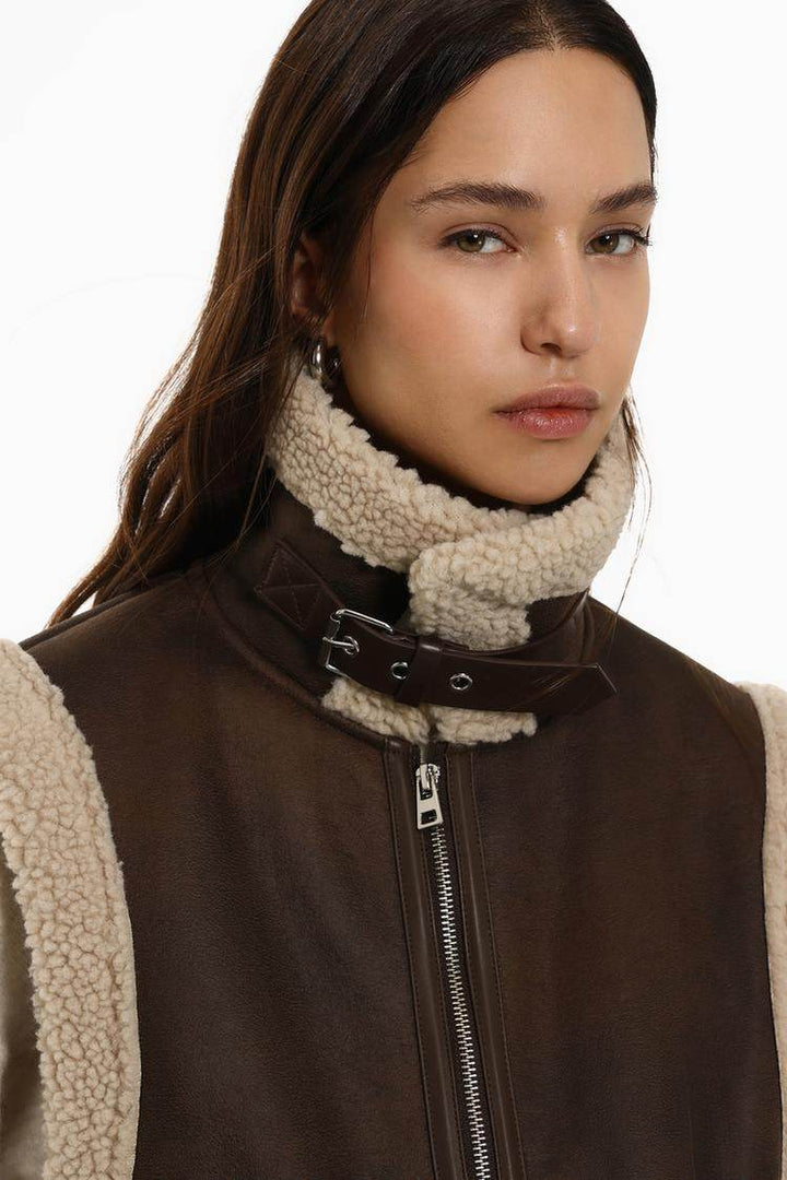 Close-up front view of brown double-faced gilet with zip

