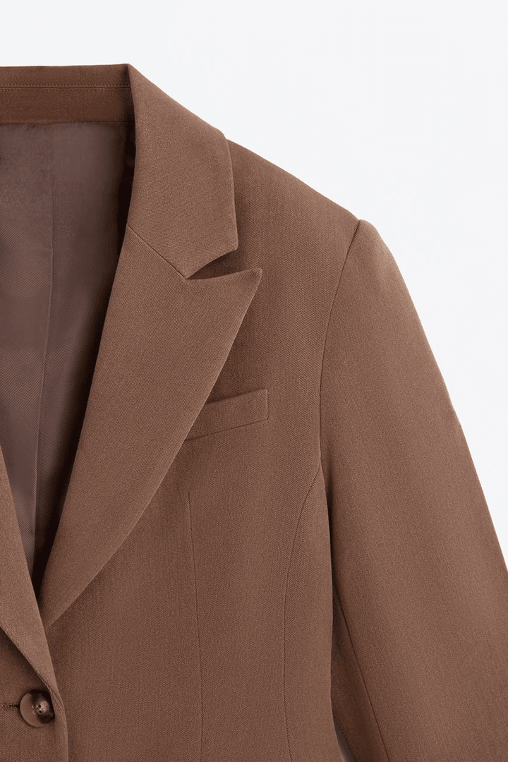 Close-up zoom of the soft brown blazer fabric and buttons

