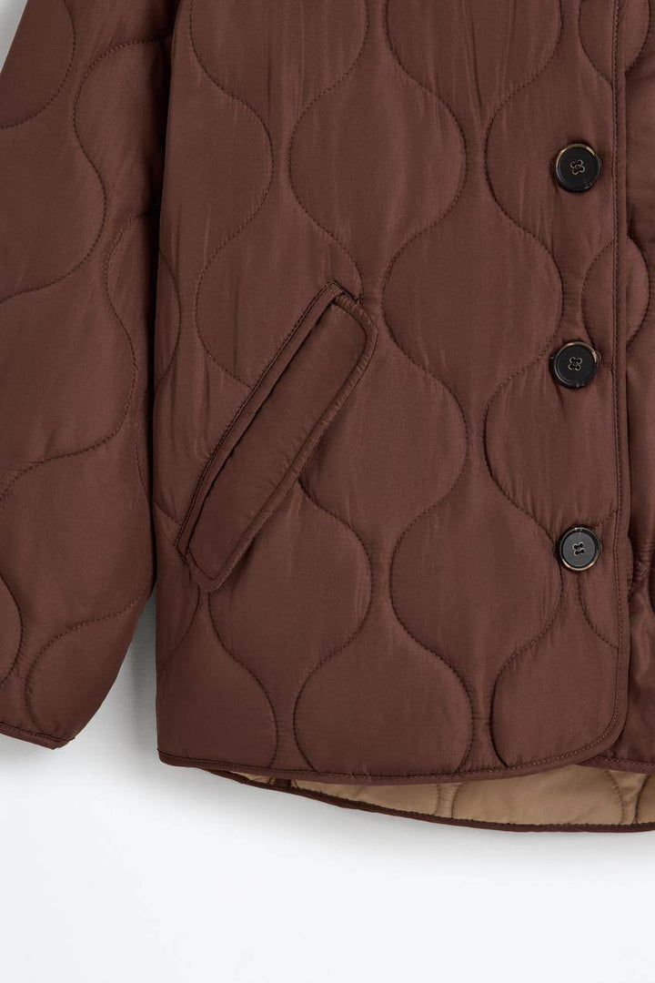 Zoomed out product image of the brown quilted jacket


