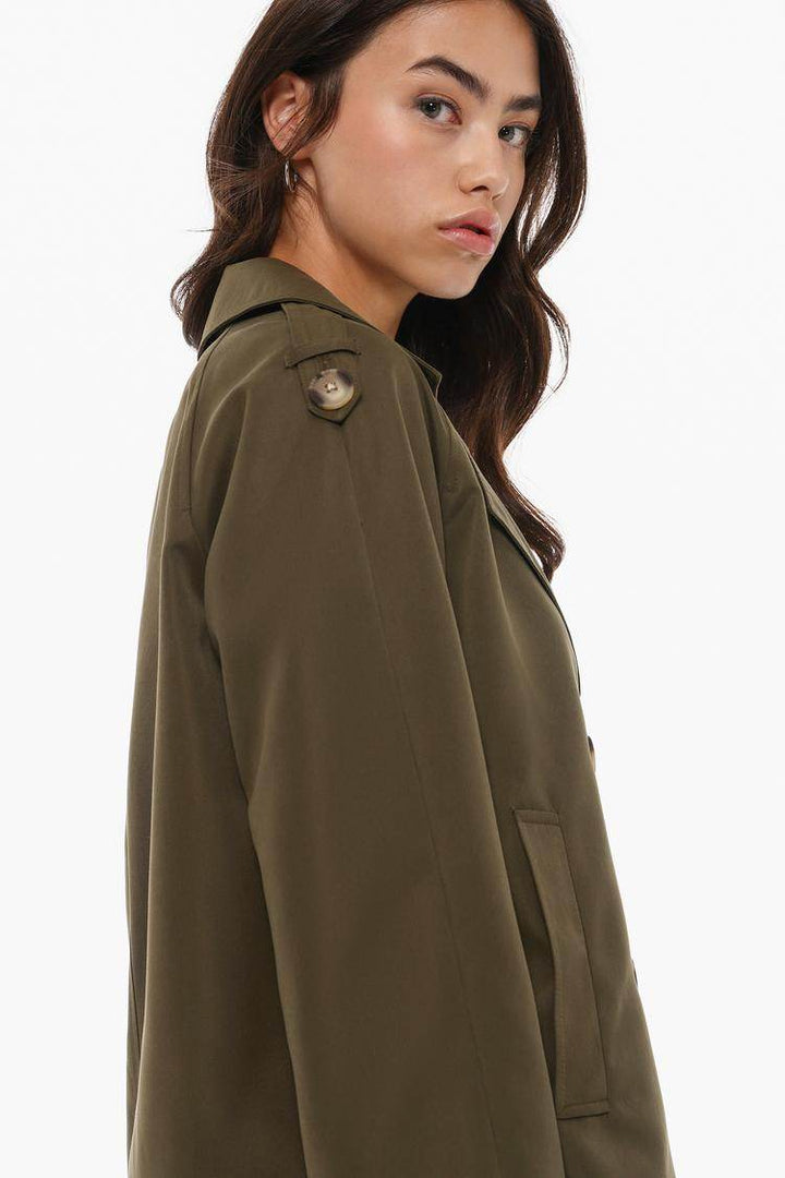 Side view of the women's dark green short oversize trench coat

