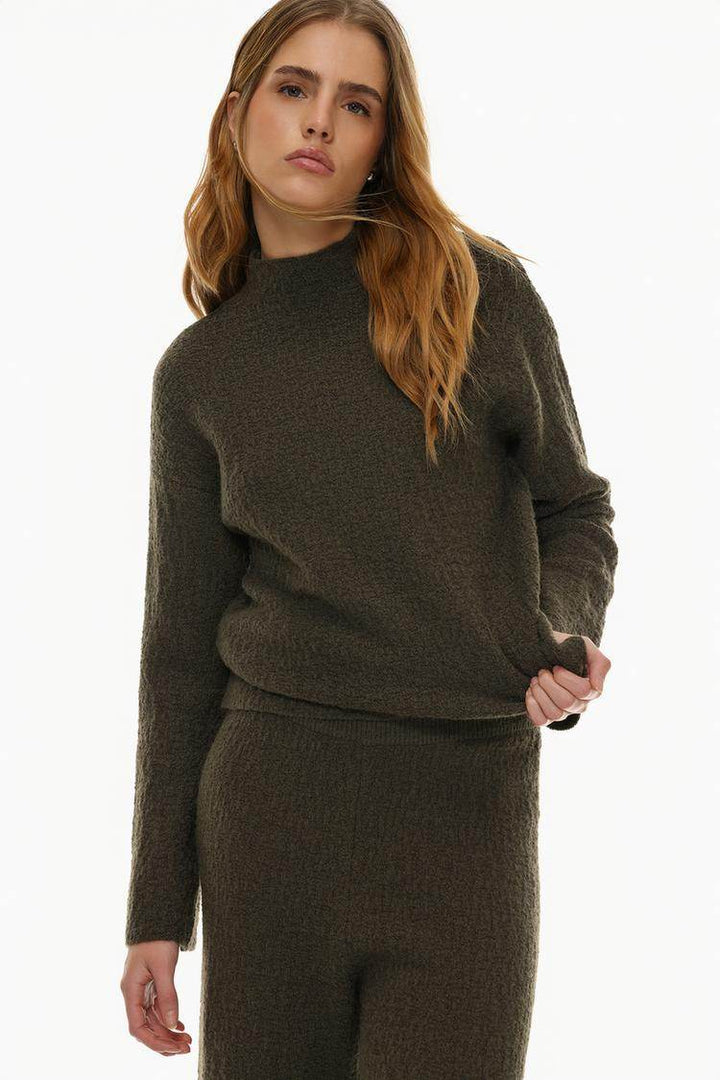 Front view of women's dark green textured knit sweater

