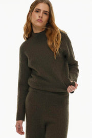 Front view of women's dark green textured knit sweater

