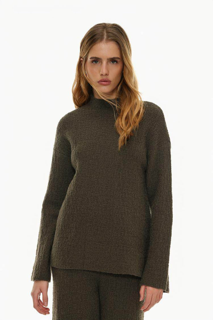 Model showcasing dark green textured knit sweater

