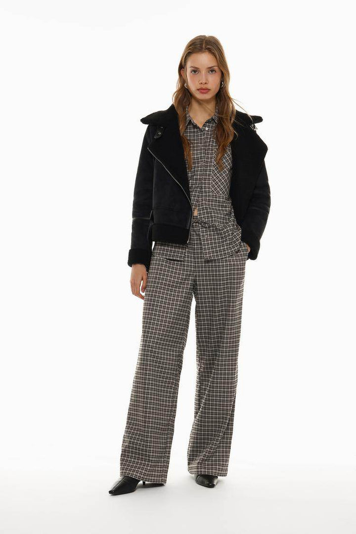 Full body front view of woman wearing grey checked shirt

