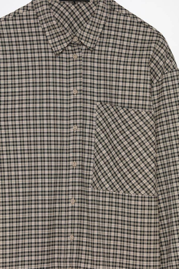Close-up product image of grey checked shirt

