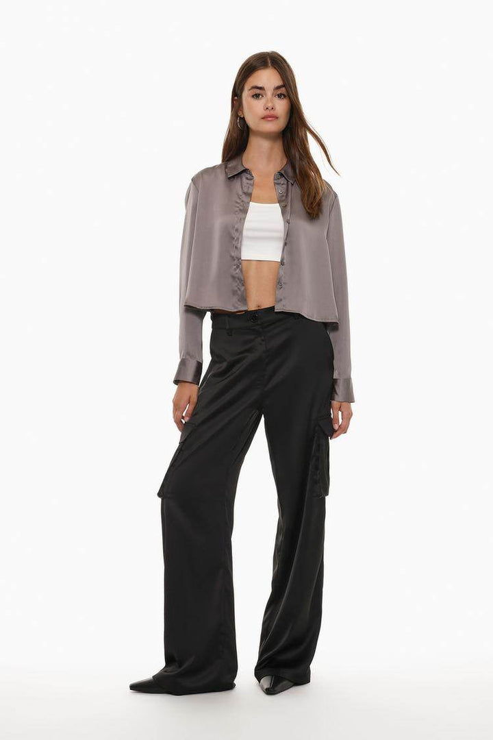 Full body front view of woman wearing grey cropped satin shirt

