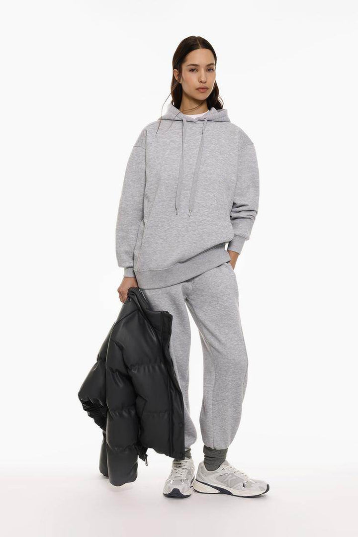 Full body front view of woman wearing grey oversized plush sweatshirt

