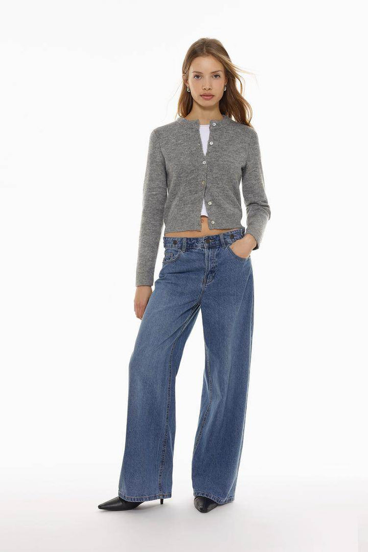 Full body front view of woman wearing grey knit cardigan

