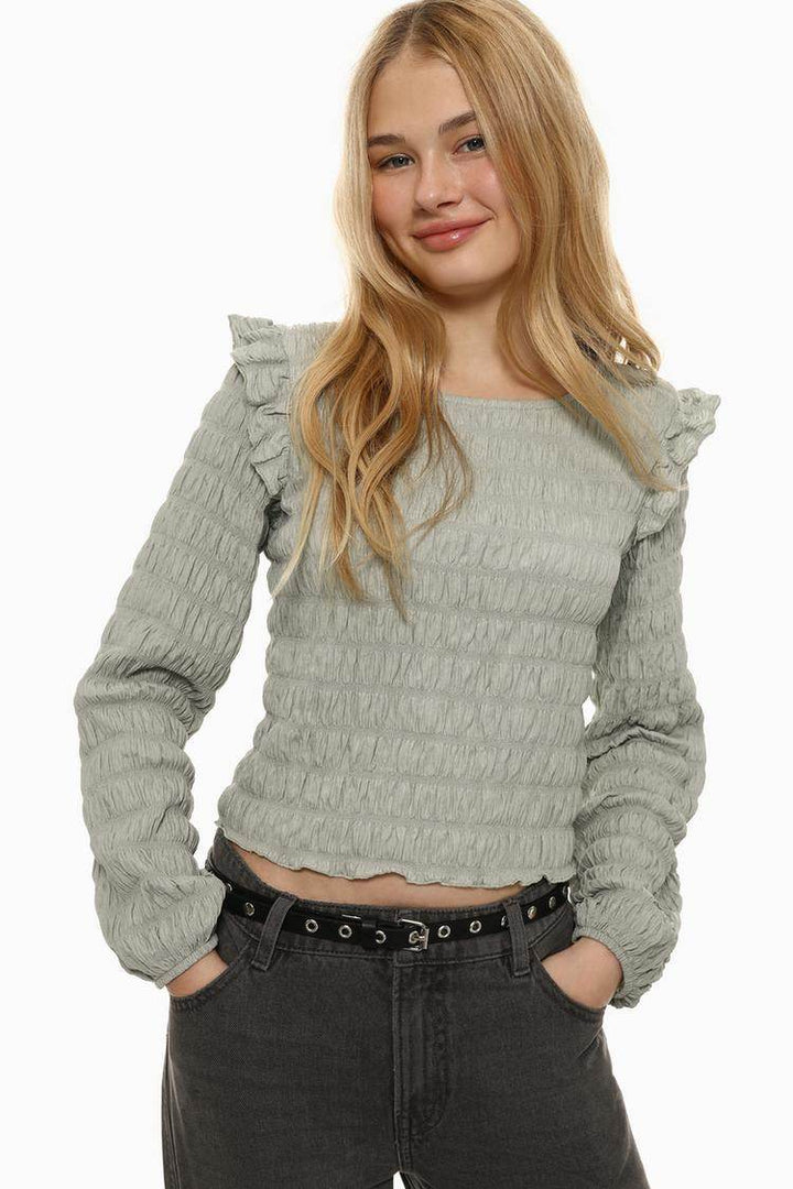 Close-up front view of grey ruffle blouse

