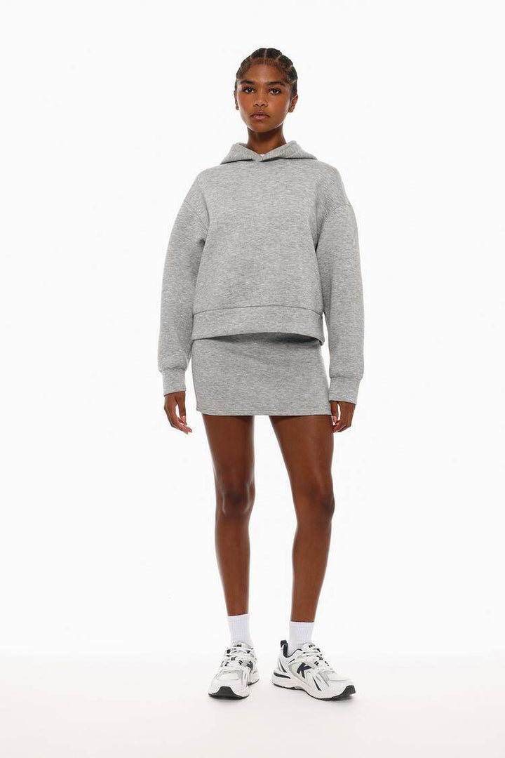 Full body front view of woman wearing grey tracksuit hoodie

