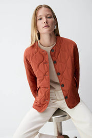 Close-up front view of the women's orange quilted jacket


