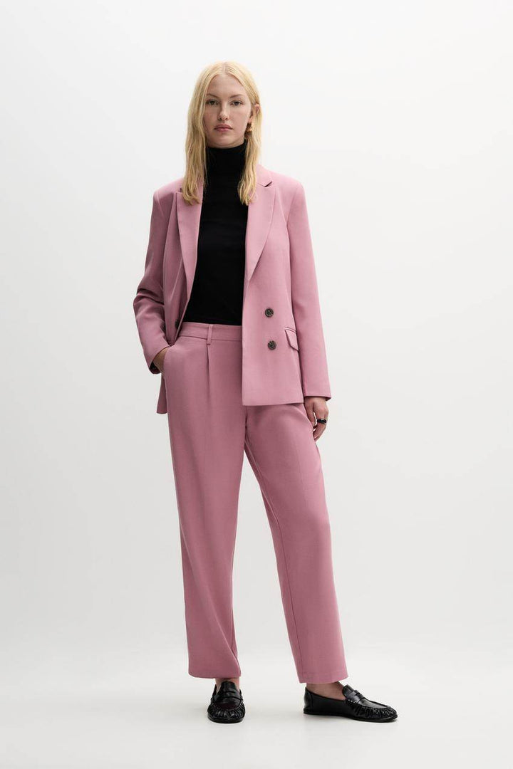 Full body front view of a woman in a pink blazer

