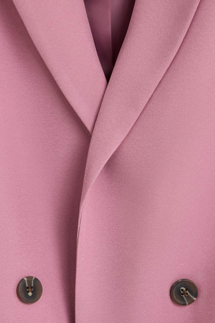 Close-up of the pink blazer's fabric and texture

