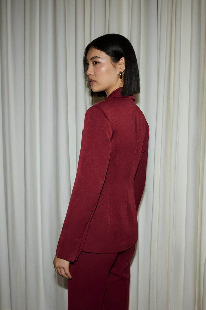 Side view of a red women's fitted blazer
