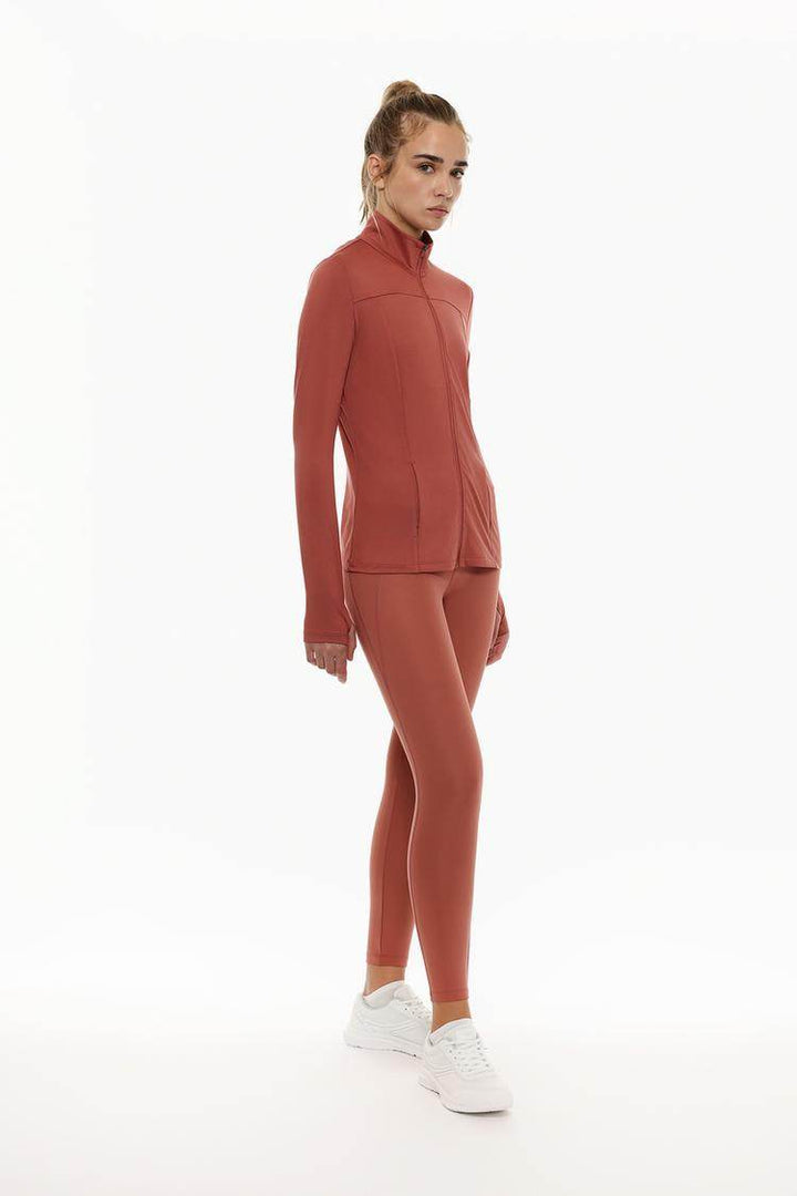 Full body front view of woman wearing red sports jacket

