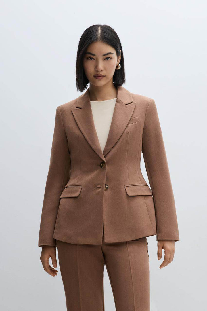A woman wearing a chic brown fitted blazer, front view